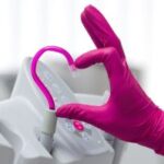 ways to thank your travel dentist: a dentist making a hand heart with a dentistry tool