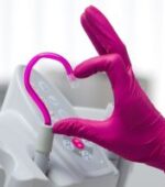 ways to thank your travel dentist: a dentist making a hand heart with a dentistry tool