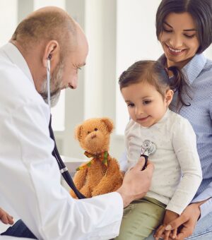 A doctor listens to a child's breathing through a stethoscope