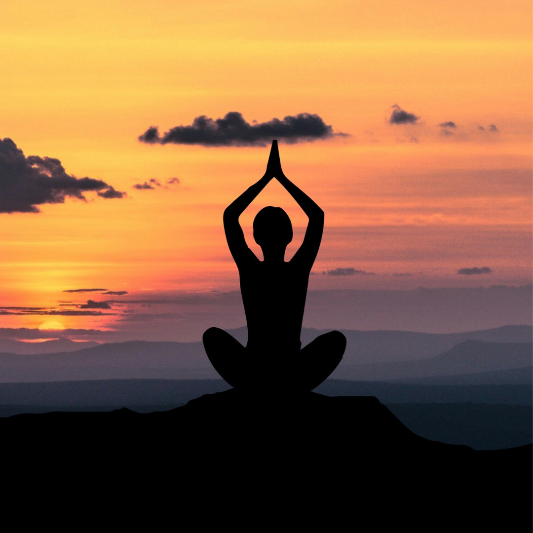 A person doing yoga during a sunset