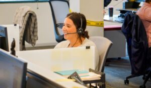 A woman laughing while she takes a work call