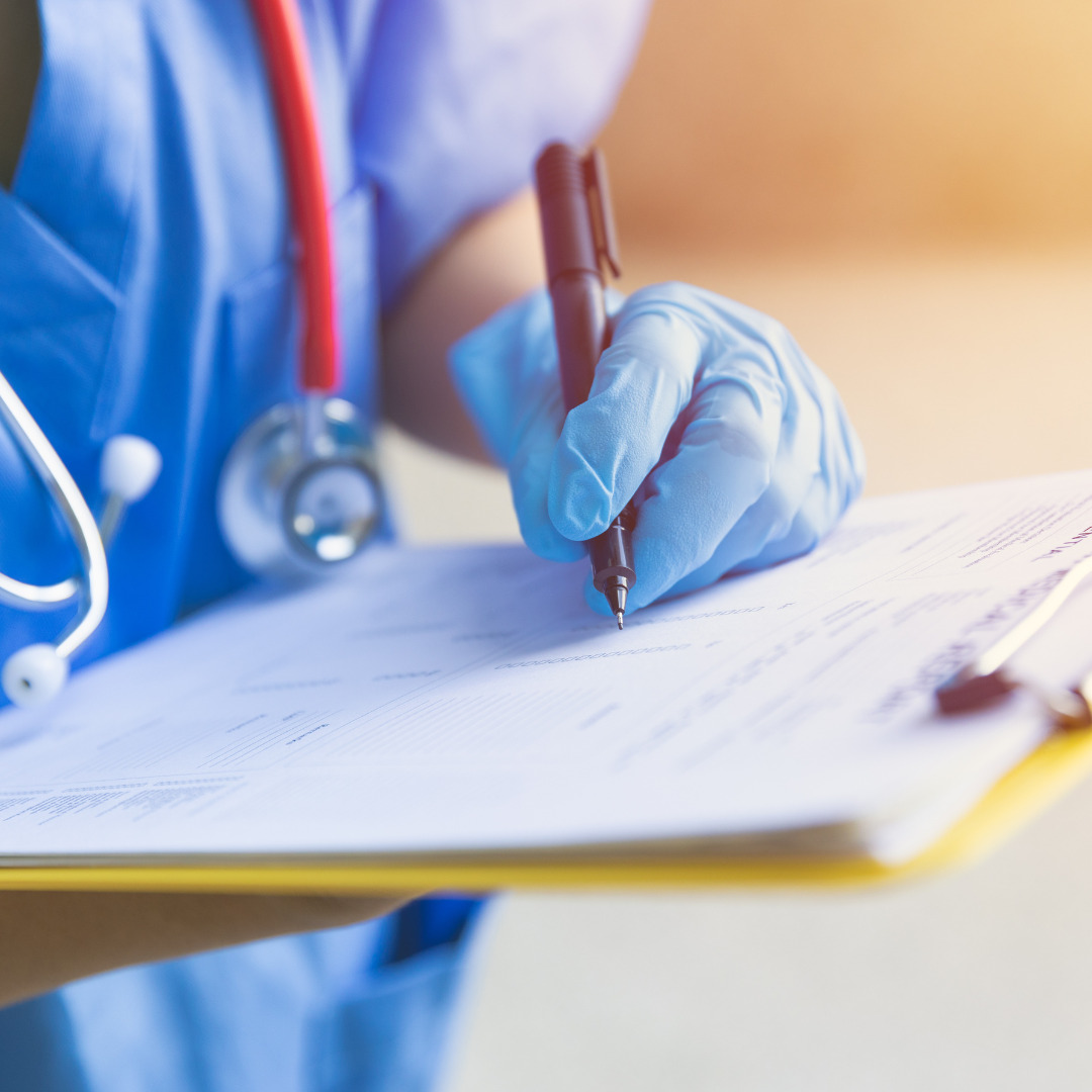 A nurse writing on a clipboard