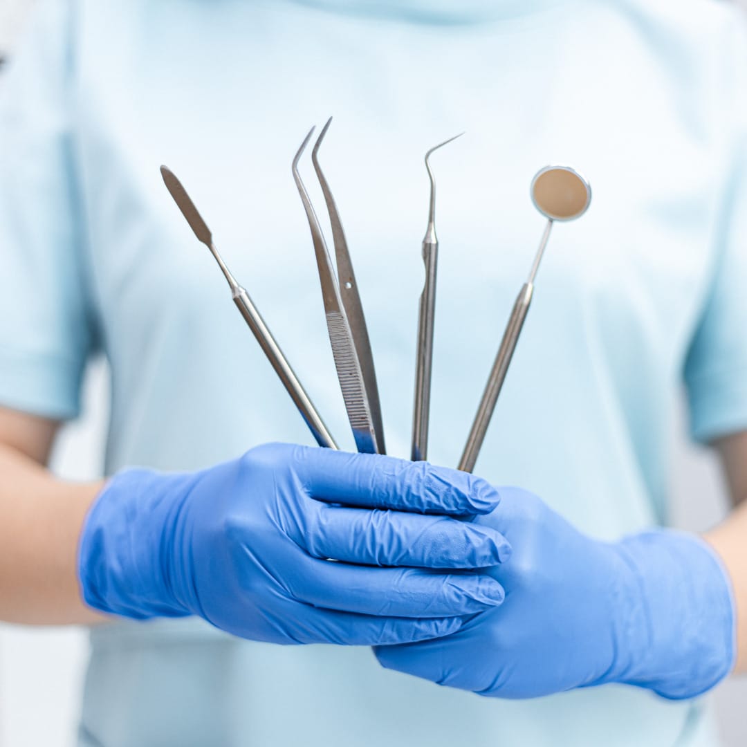 A dentist holds up dental tools