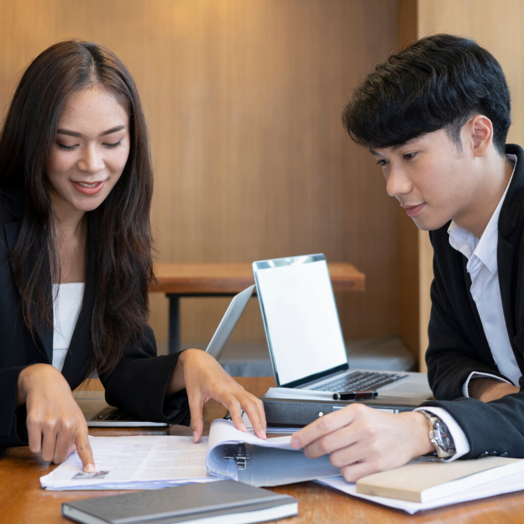 Two professionals talk and look at documents