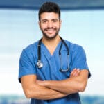 A nurse practitioner smiling with his arms crossed across his chest