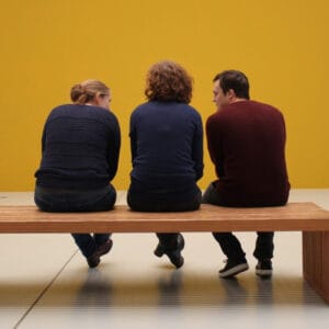 Three people sitting in a museum