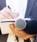 A reporter writing notes down in a notebook