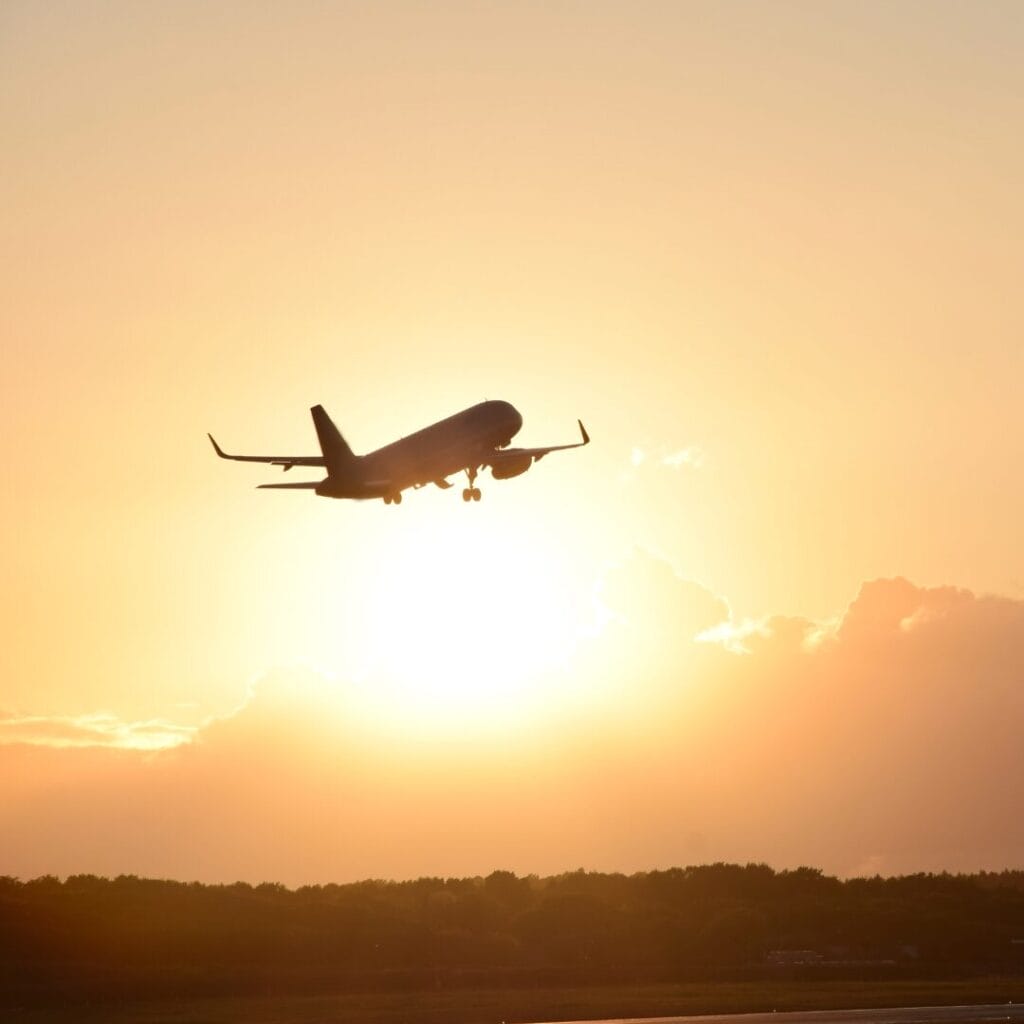 A plane taking off into the sunset