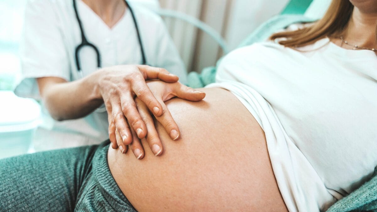An OB/GYN checking on a patient for a blog about OB/GYN employment opportunities